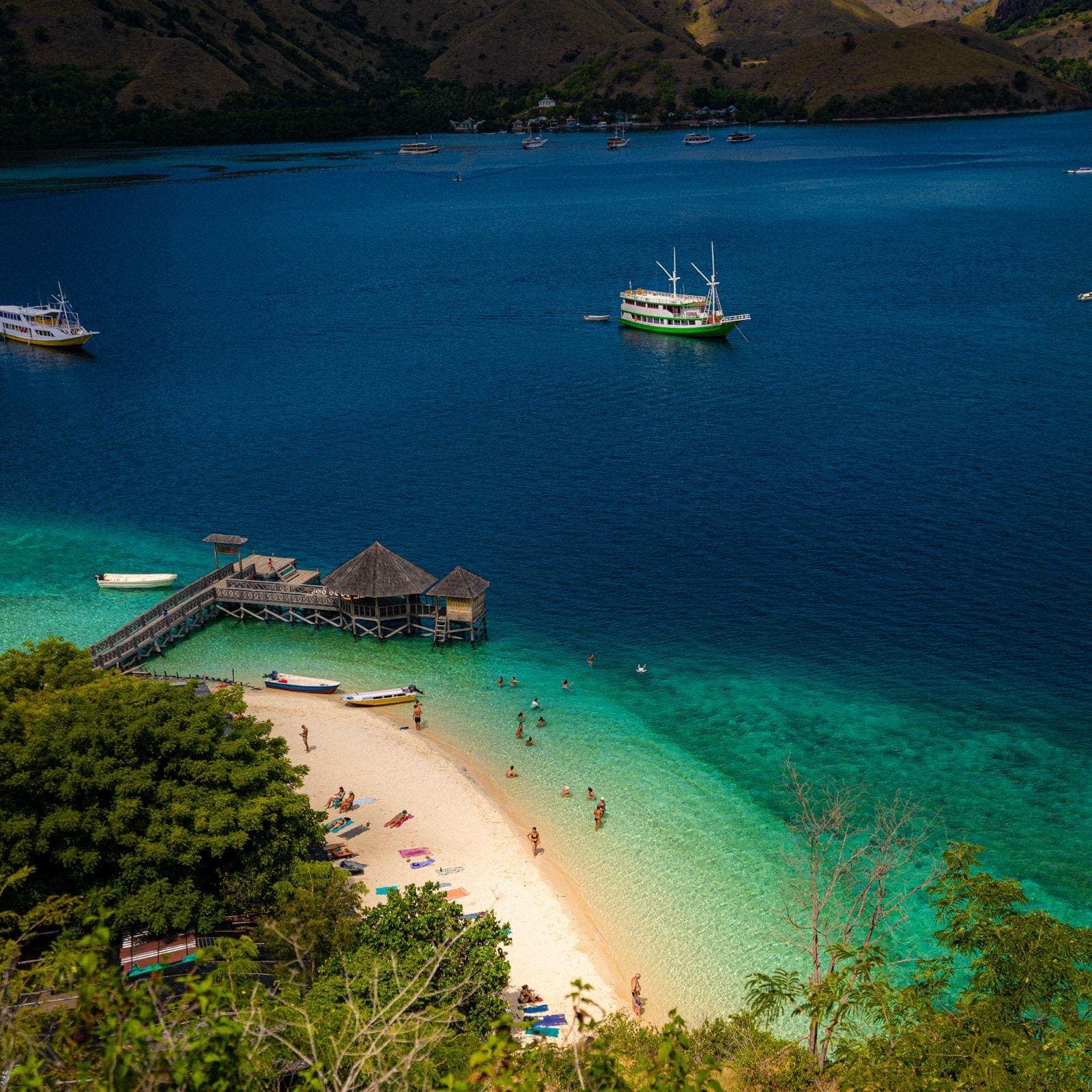 A wooden phinisi anchored off Padar Island at sunset